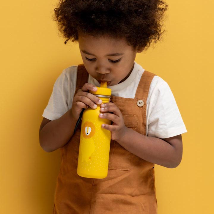 Toddler holding and drinking from a Trixie 500ml water bottle with a fun animal design of Mr. Lion.